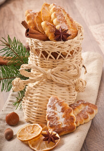 Wicker Christmas stocking filled with cookies, cinnamon sticks, candied lemon and star anise