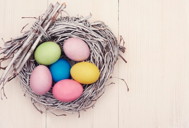Wicker nest full of multi colored eggs