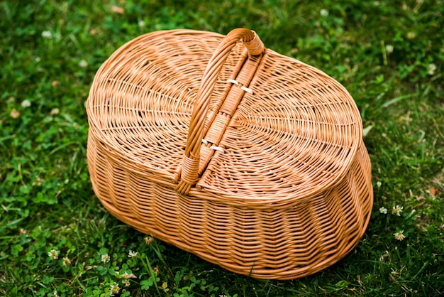 Wicker picnic basket on grass top view