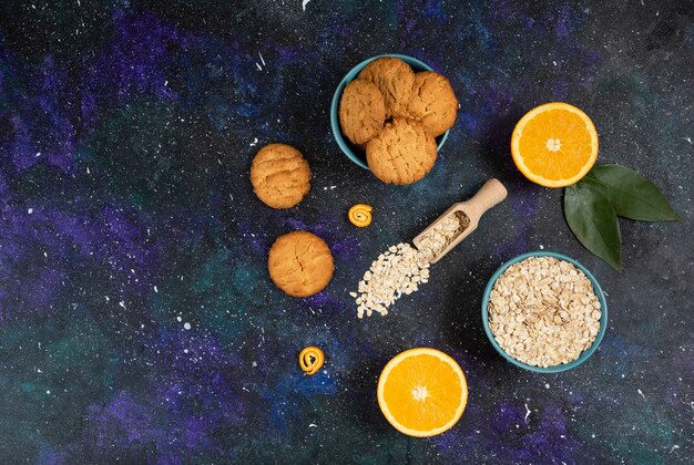 Wide angle photo of cookies with orange and oatmeal over space surface.