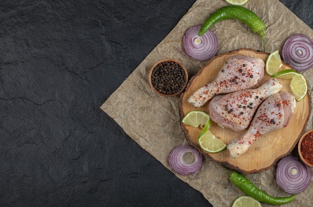 Free photo wide angle photo of raw chicken drumsticks and vegetables