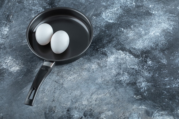 Wide angle photo of two chicken egg on frying pan