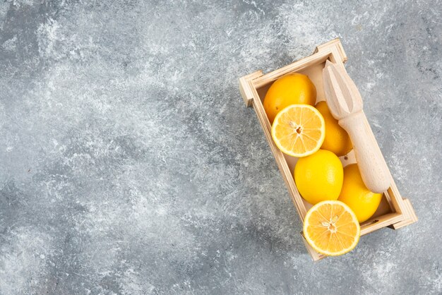 Wide angle photo of wooden box full with fresh lemons.