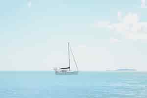 Free photo wide angle shot of a boat on top of an ocean under a clear sunny sky