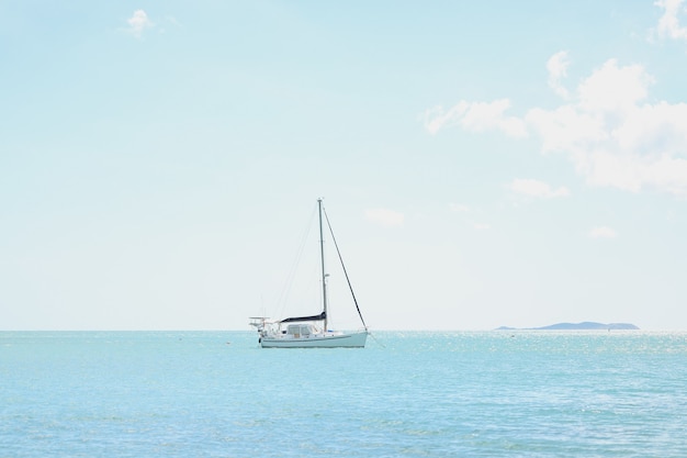 Wide angle shot of a boat on top of an ocean under a clear sunny sky