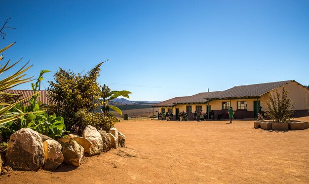 Wide angle shot of houses built on a dry field next to a few plants