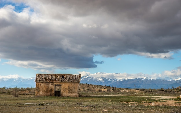 Wide angle shot of an old house on a mountain under a cloudy sky