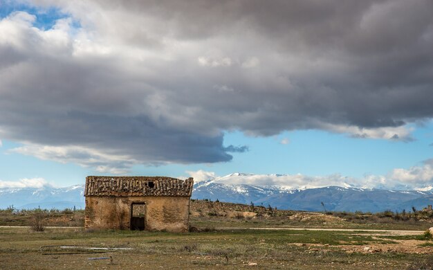 Wide angle shot of an old house on a mountain under a cloudy sky