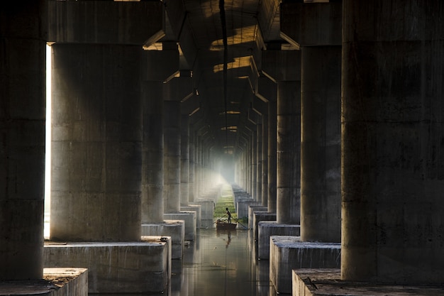 Free photo wide angle shot of a person sailing on a small boat surrounded with large columns