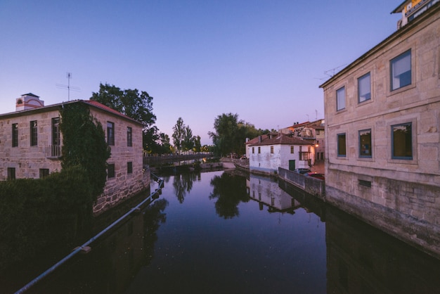 Wide angle shot of a river flowing through the city surrounded by buildings