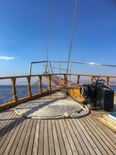 Wide angle shot of a rope twisted in a circular position on a ship over the ocean under a blue sky