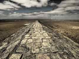 Foto gratuita colpo grandangolare di una passerella in pietra circondata dal deserto