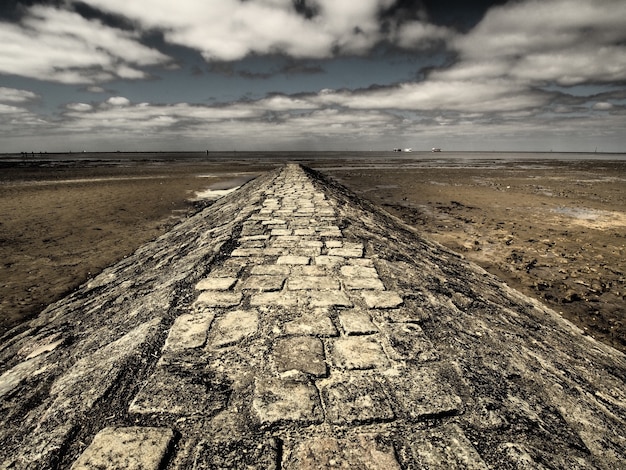 Wide angle shot of a walkway made of stone surrounded by the desert