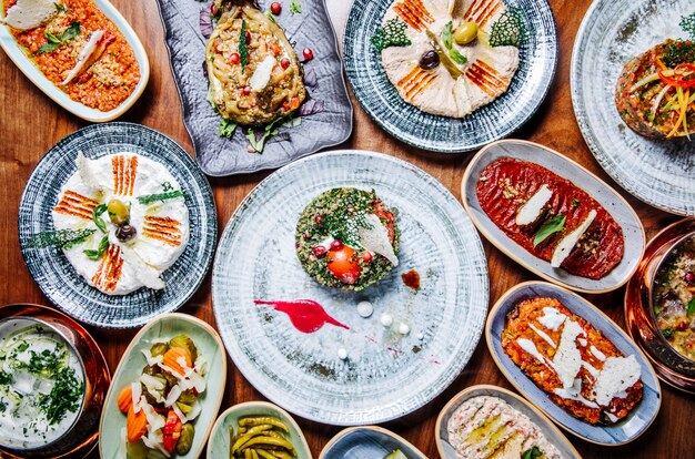 Wide selection of eastern, oriental foods in rustic plates on the table.