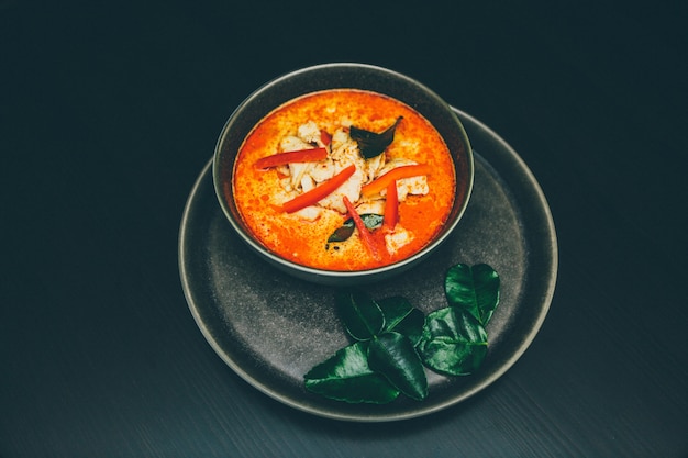 Wide selective shot of spicy seafood soup in a bowl on a platter