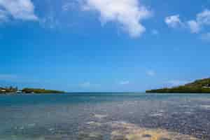 Free photo wide shot of a beautiful view of the ocean with a cloudy blue sky