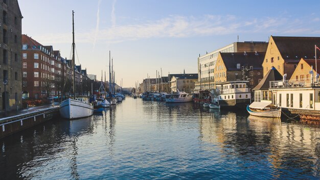 Wide shot of boats on the body of water near buildings in Christianshavn, Copenhagen, Denmark