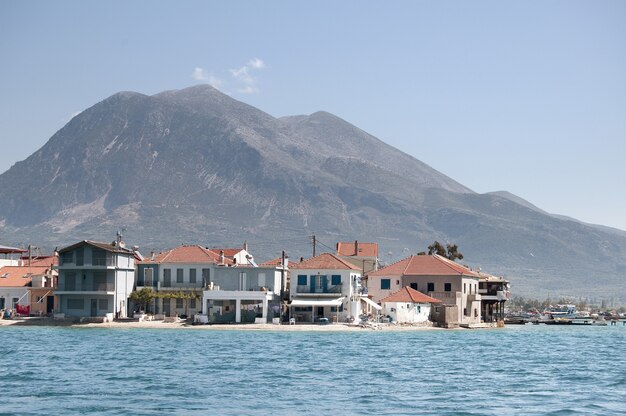 Wide shot of buildings on the shore of the beach with mountains at Northern Greek