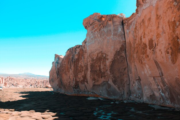 Wide shot of a cliff in the desert with a clear blue