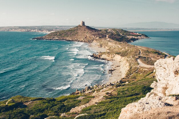 Wide shot of a cliff and a hill by the sea