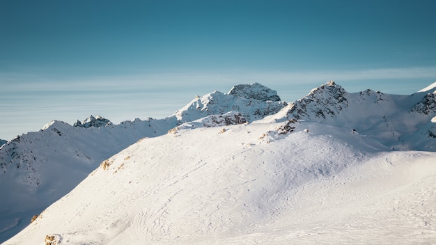 ハーフムーンと澄んだ青い空の下で雪に覆われた山々のワイドショット