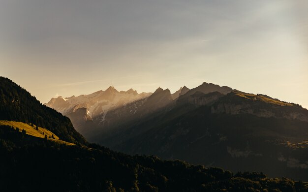 Wide shot of mountains and green hills under a sunny sky