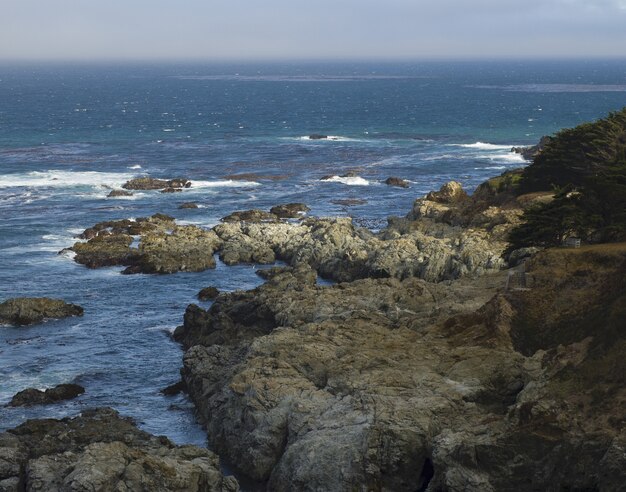 Wide shot of an ocean with rocks around the shore