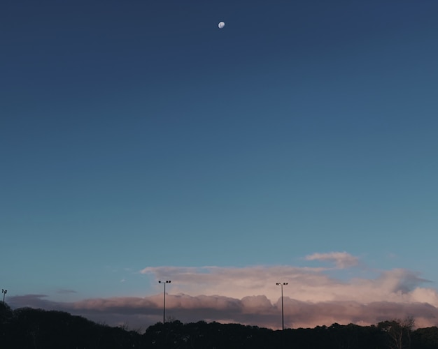 無料写真 灰色の雲の上の空に半月のワイドショット