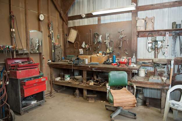다양한 유형의 도구가있는 오래된 헛간 작업대의 와이드 샷