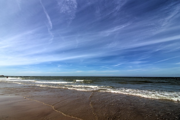 Wide shot of a sandy beach with a clear blue sky