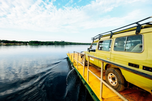 Free photo wide shot of a yellow van on a yellow dock by the sea under a clear sky with clouds