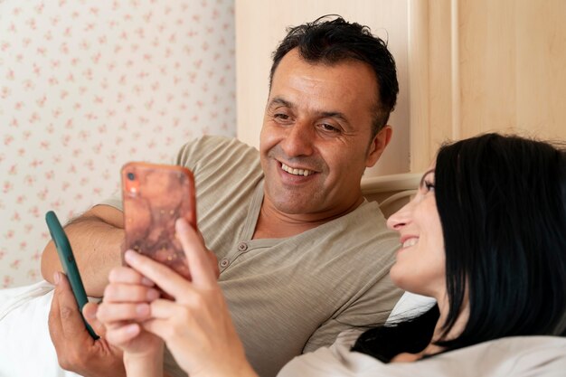 Wife and husband checking their phone in bed