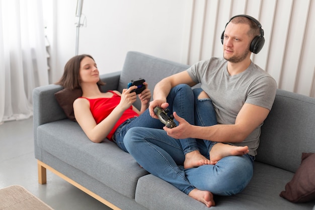 Wife and husband playing videogames together at home