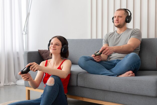 Wife and husband playing videogames together at home