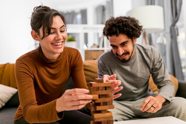 Wife and husband playing a wooden tower game