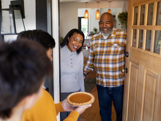 Wife and husband welcoming relatives for the thanksgiving day dinner