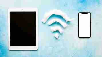 Free photo wifi symbol in between cell phone and tablet on blue background