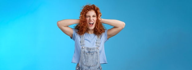 Free photo wild daring rebellious cool stylish redhead curly girl having fun playful exciting mood touch hair y