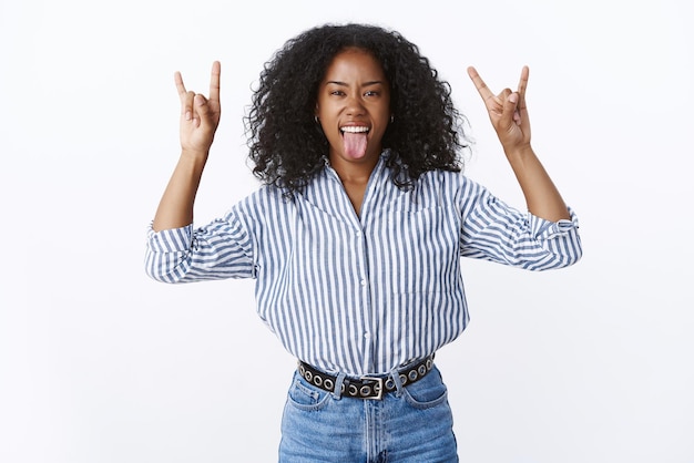 Free photo wild good-looking  african american woman  having fun showing heavy metal gestures