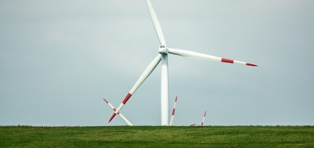 Free photo wind fan standing on a green landscape during daytime