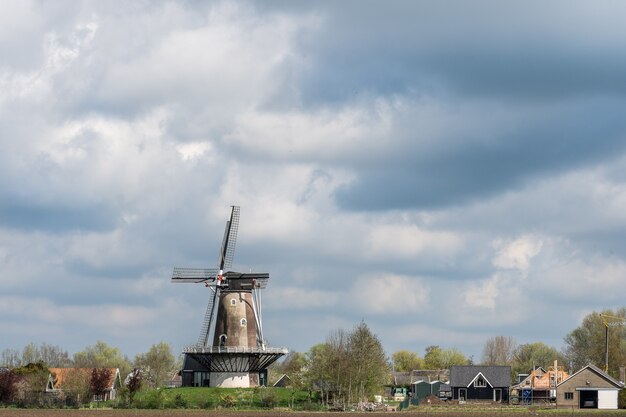 Windmill standing under a cloudy sky at daytime