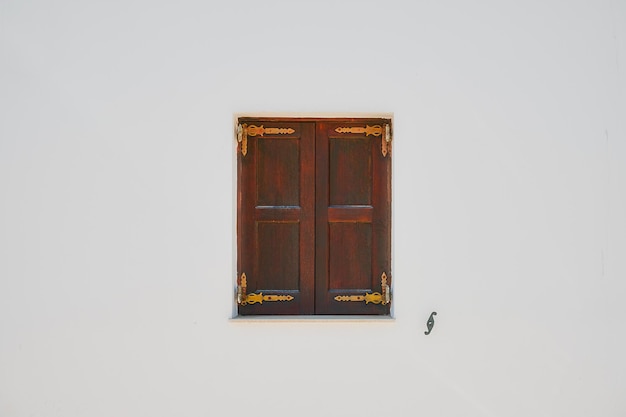 Бесплатное фото Окно с закрытыми ставнями на белой стене дома греческая улица города линдос остров родос греческие острова архипелага додеканес европа