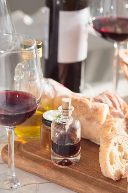 Foto gratuita vino, baguette e formaggio su fondo di legno