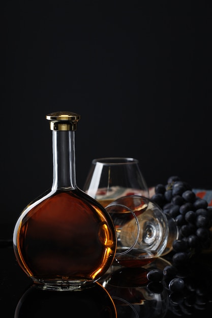 Foto gratuita bottiglia di vino con calice e uva