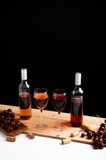 Винные бутылки и виноград с черным фоном