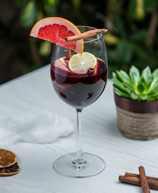 Free photo wine glass with cinnamon grapefruit and other fruits