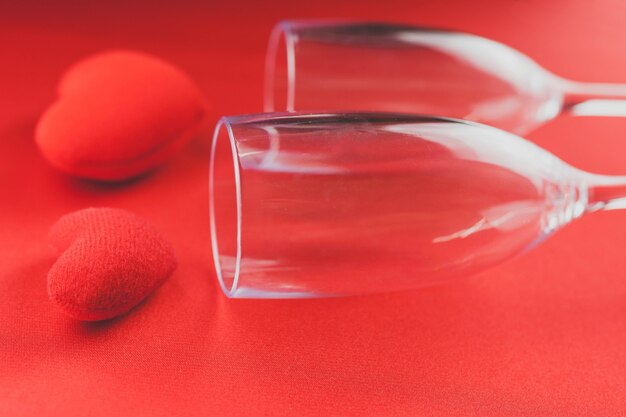 心と赤いテーブルの上に横たわっているワイングラス