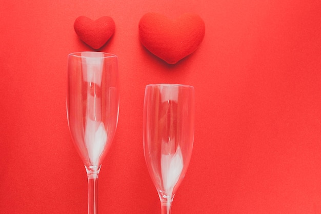 Free photo wine glasses lying on a red table with hearts