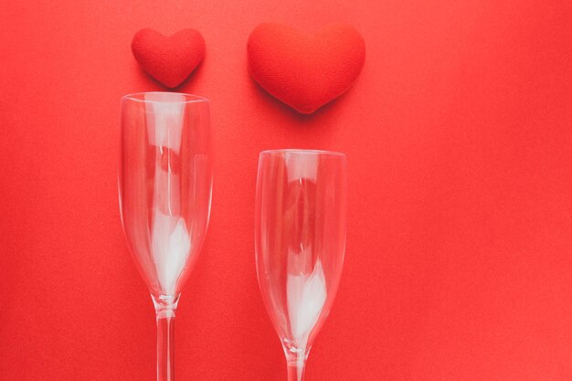 Wine glasses lying on a red table with hearts