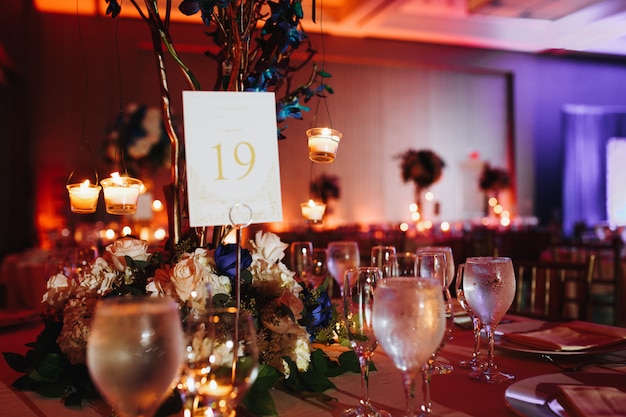 Wine glasses on the served table with lightening candles and table number on it